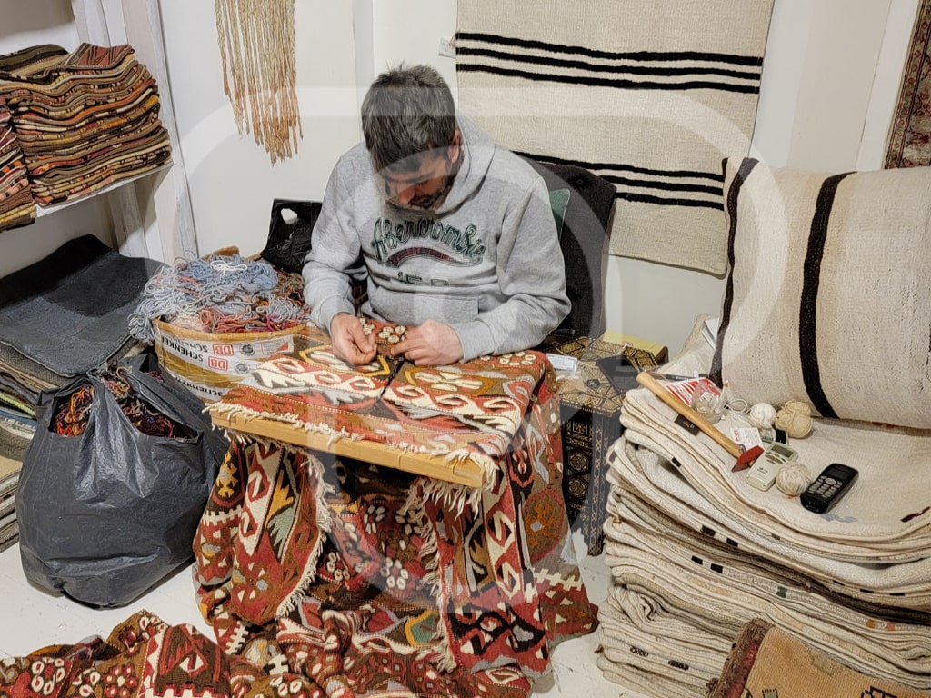 Turkish artisan weaving a carpet